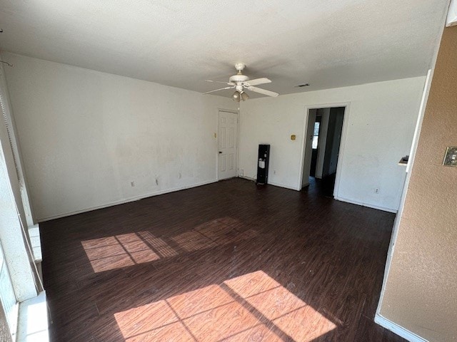 spare room featuring ceiling fan and dark wood-type flooring