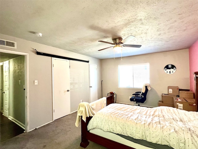 bedroom featuring dark colored carpet, ceiling fan, and a textured ceiling