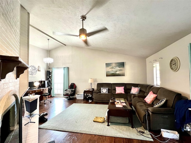 living room with hardwood / wood-style flooring, ceiling fan, lofted ceiling, and a textured ceiling