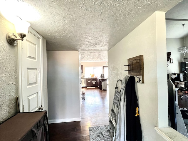 corridor with dark hardwood / wood-style flooring and a textured ceiling