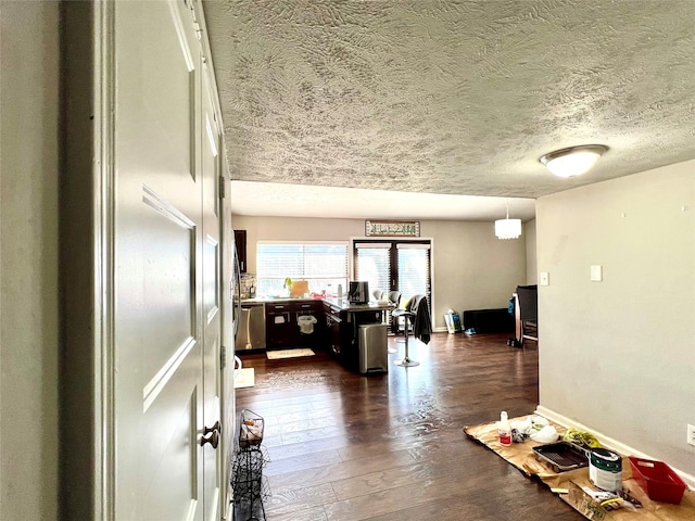 interior space featuring a textured ceiling and dark wood-type flooring