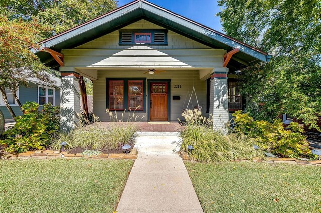 bungalow featuring ceiling fan, a porch, and a front yard