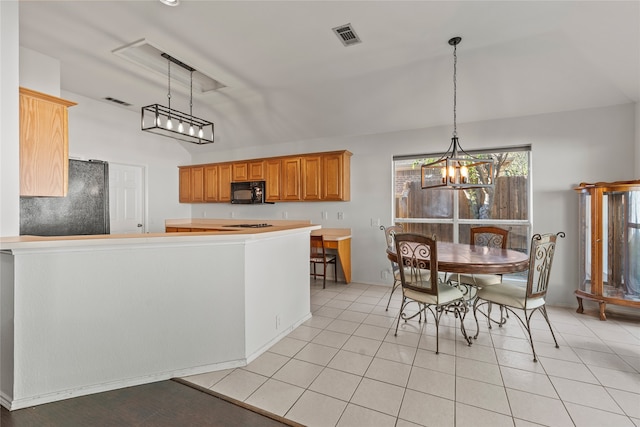 kitchen featuring decorative light fixtures, light tile patterned flooring, lofted ceiling, and fridge