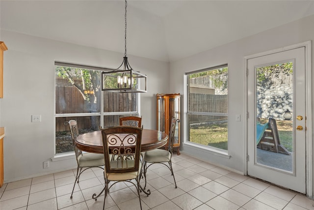 dining space with light tile patterned floors, a healthy amount of sunlight, and a notable chandelier