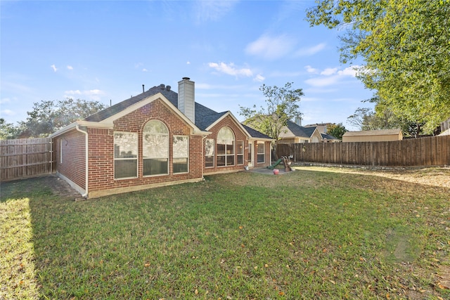 rear view of property featuring a lawn