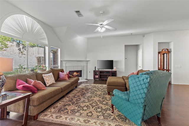 living room featuring ceiling fan, dark hardwood / wood-style flooring, lofted ceiling, and a fireplace