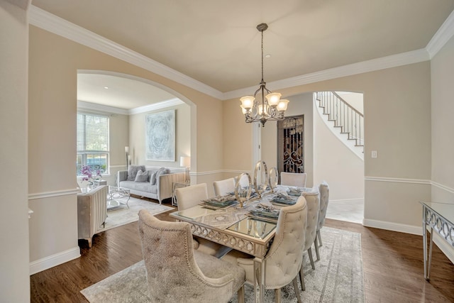 dining space featuring hardwood / wood-style flooring, ornamental molding, and a chandelier