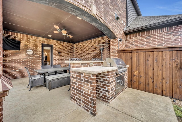 view of patio / terrace with exterior bar, grilling area, ceiling fan, and an outdoor kitchen