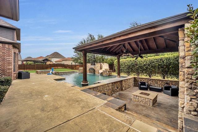 view of pool featuring pool water feature, a patio area, a gazebo, an outdoor fire pit, and ceiling fan