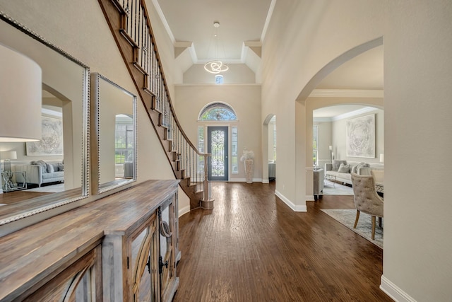 foyer with a high ceiling, crown molding, and dark hardwood / wood-style flooring