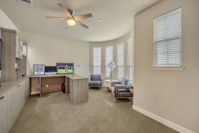 carpeted office featuring a textured ceiling and ceiling fan