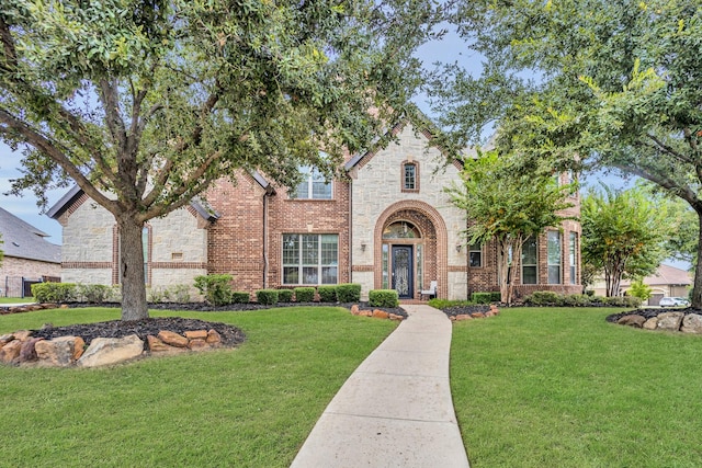 english style home featuring a front yard