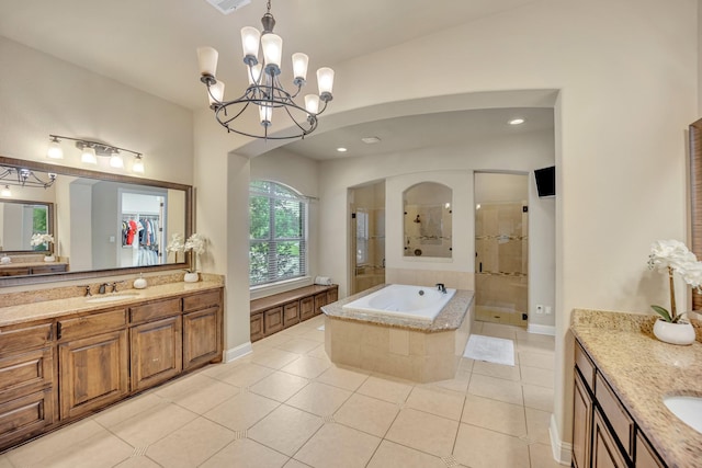 bathroom featuring tile patterned flooring, shower with separate bathtub, a notable chandelier, and vanity