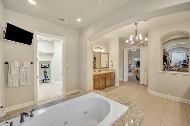 bathroom with a relaxing tiled tub, vanity, a chandelier, and tile patterned flooring