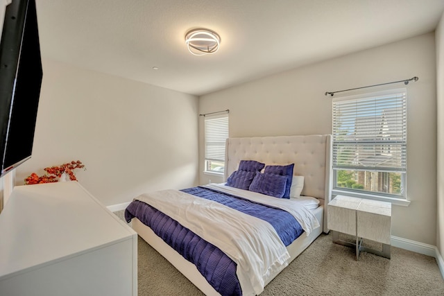 carpeted bedroom featuring multiple windows