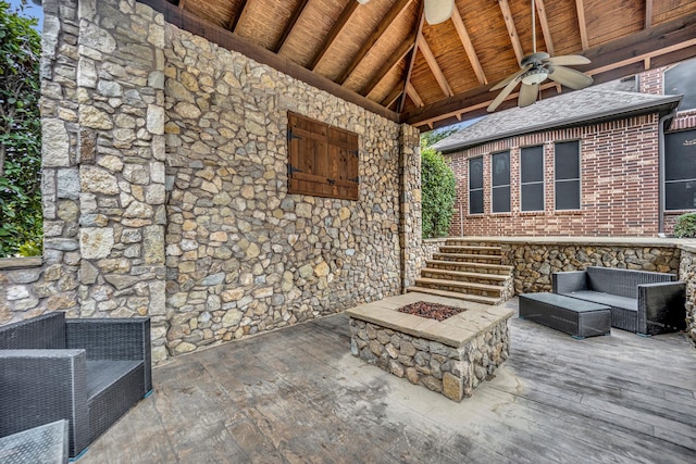 view of patio / terrace with a wooden deck, ceiling fan, and an outdoor living space with a fire pit