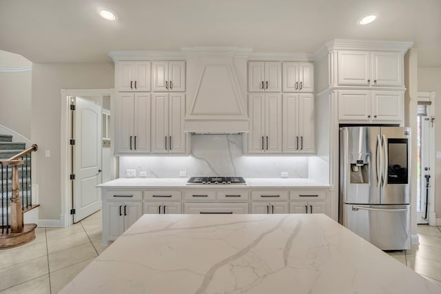 kitchen with custom exhaust hood, appliances with stainless steel finishes, and white cabinets