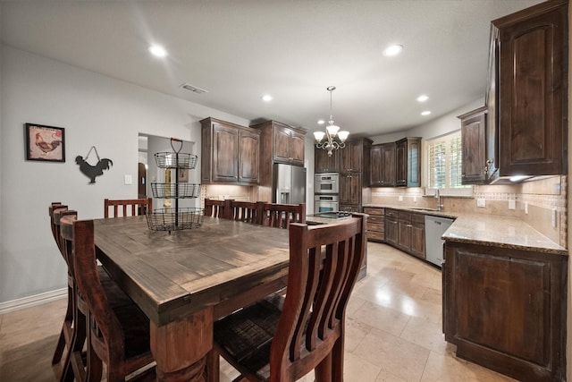 dining area featuring sink and an inviting chandelier