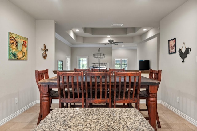 dining area featuring ceiling fan and a tray ceiling