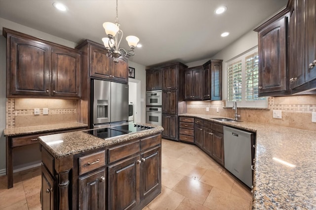 kitchen featuring hanging light fixtures, stainless steel appliances, light stone countertops, sink, and dark brown cabinets