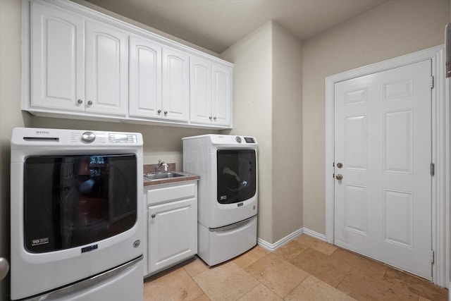 clothes washing area featuring washer and dryer, cabinets, and sink