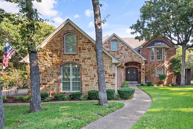 tudor-style house featuring a front yard