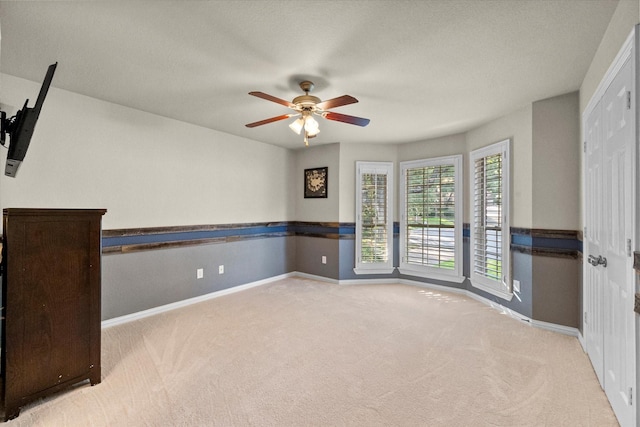 spare room featuring ceiling fan and light colored carpet