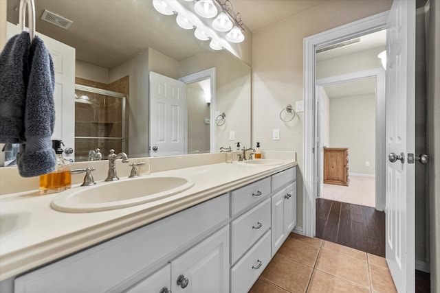 bathroom with vanity, an enclosed shower, and tile patterned floors