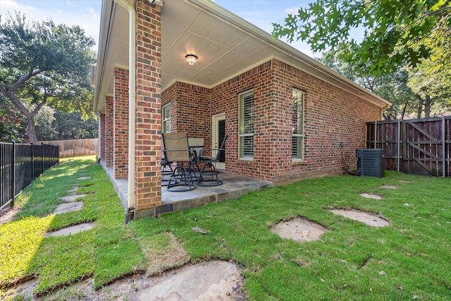 view of side of home with a patio, a yard, and central air condition unit