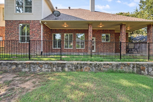 rear view of house featuring a lawn