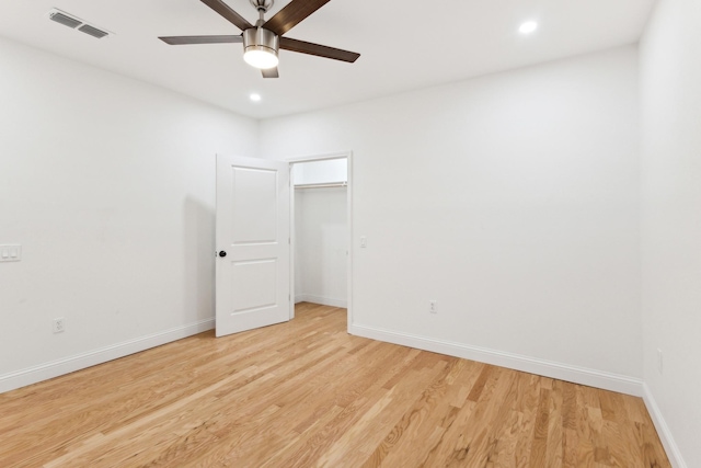 unfurnished bedroom with ceiling fan, a closet, light hardwood / wood-style floors, and a spacious closet