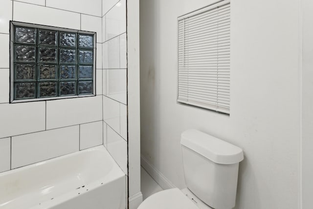 bathroom with tiled shower / bath combo and toilet