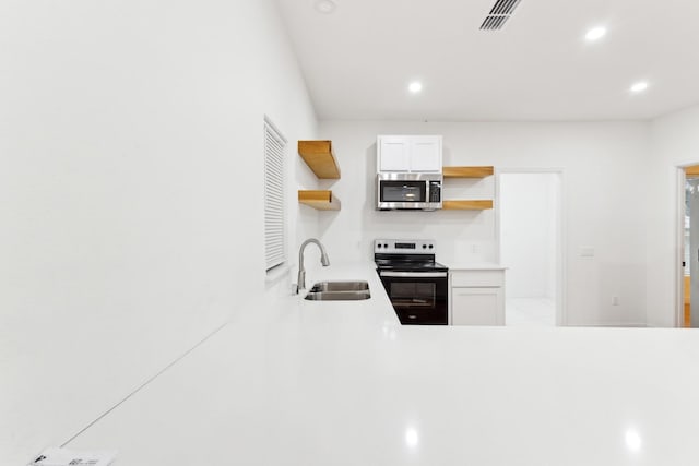 kitchen with sink, white cabinets, and stainless steel appliances