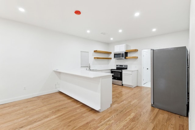 kitchen featuring kitchen peninsula, light hardwood / wood-style flooring, white cabinets, and stainless steel appliances