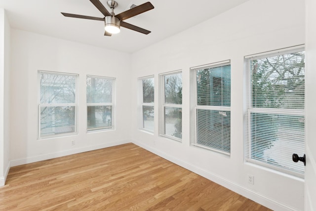 unfurnished sunroom with ceiling fan