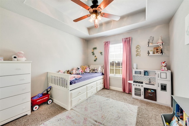 bedroom featuring light carpet, a raised ceiling, and ceiling fan