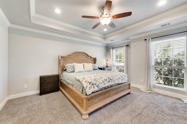 carpeted bedroom featuring a tray ceiling, ceiling fan, and ornamental molding