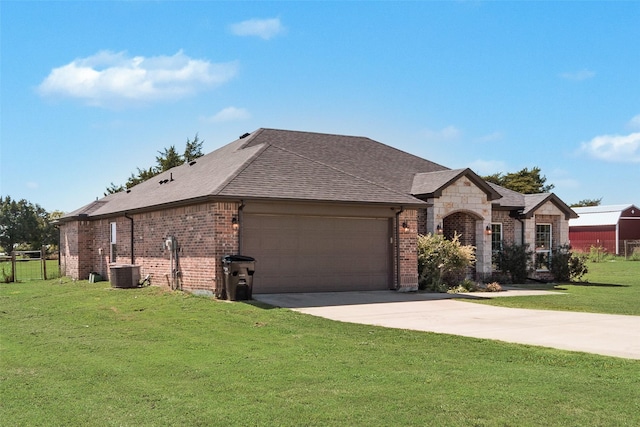 view of front of house featuring central air condition unit, a front yard, and a garage