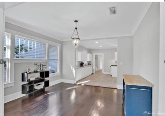 kitchen featuring blue cabinetry, an inviting chandelier, dark hardwood / wood-style floors, white cabinets, and ornamental molding