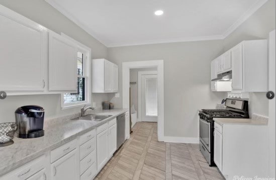 kitchen with white cabinets, crown molding, sink, appliances with stainless steel finishes, and light stone counters