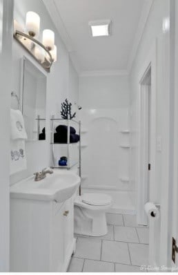 bathroom featuring vanity, tile patterned floors, toilet, ornamental molding, and walk in shower