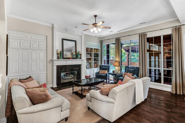 living room featuring hardwood / wood-style floors, ceiling fan, ornamental molding, and a fireplace