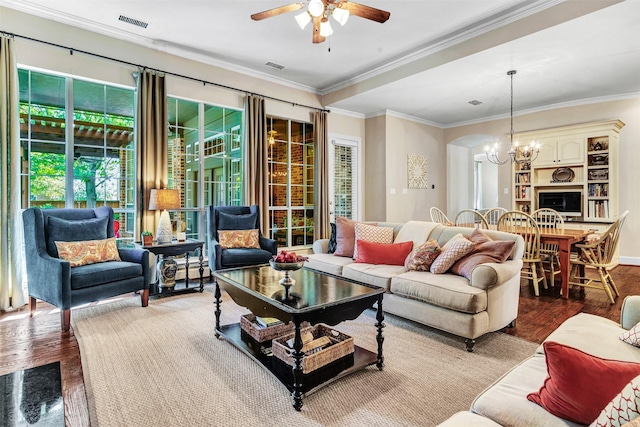 living room featuring crown molding, wood-type flooring, and ceiling fan with notable chandelier