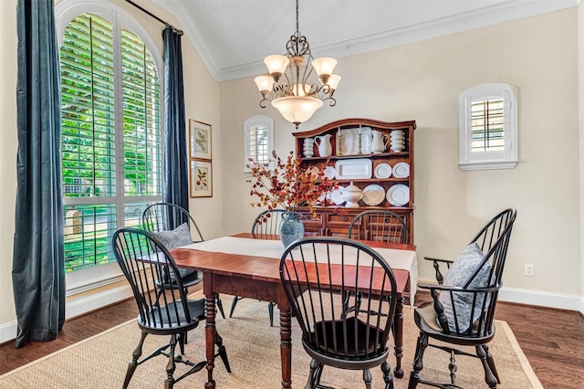 dining area featuring dark hardwood / wood-style floors, an inviting chandelier, and crown molding