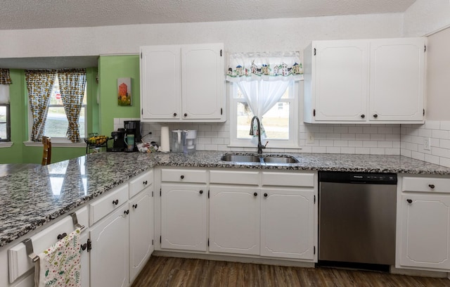 kitchen with dark hardwood / wood-style flooring, sink, white cabinets, and stainless steel dishwasher