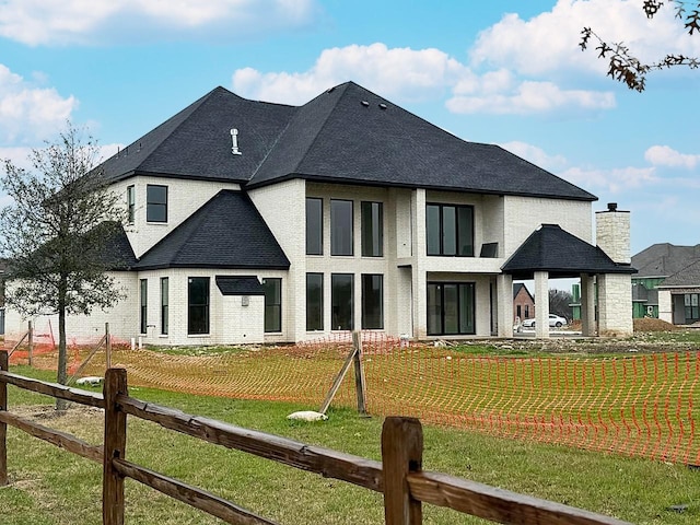 rear view of property with a lawn