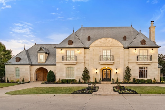 french country home with a balcony and french doors