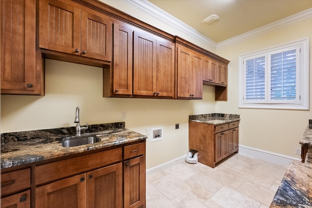 clothes washing area with cabinet space, hookup for a washing machine, hookup for an electric dryer, crown molding, and a sink