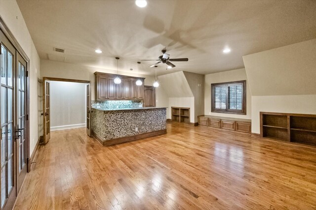 interior space with stone countertops, decorative light fixtures, light wood-style floors, backsplash, and recessed lighting