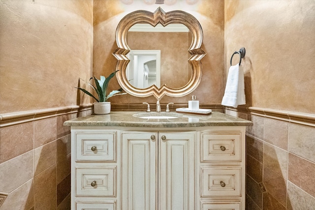 bathroom with tile walls, wainscoting, and vanity